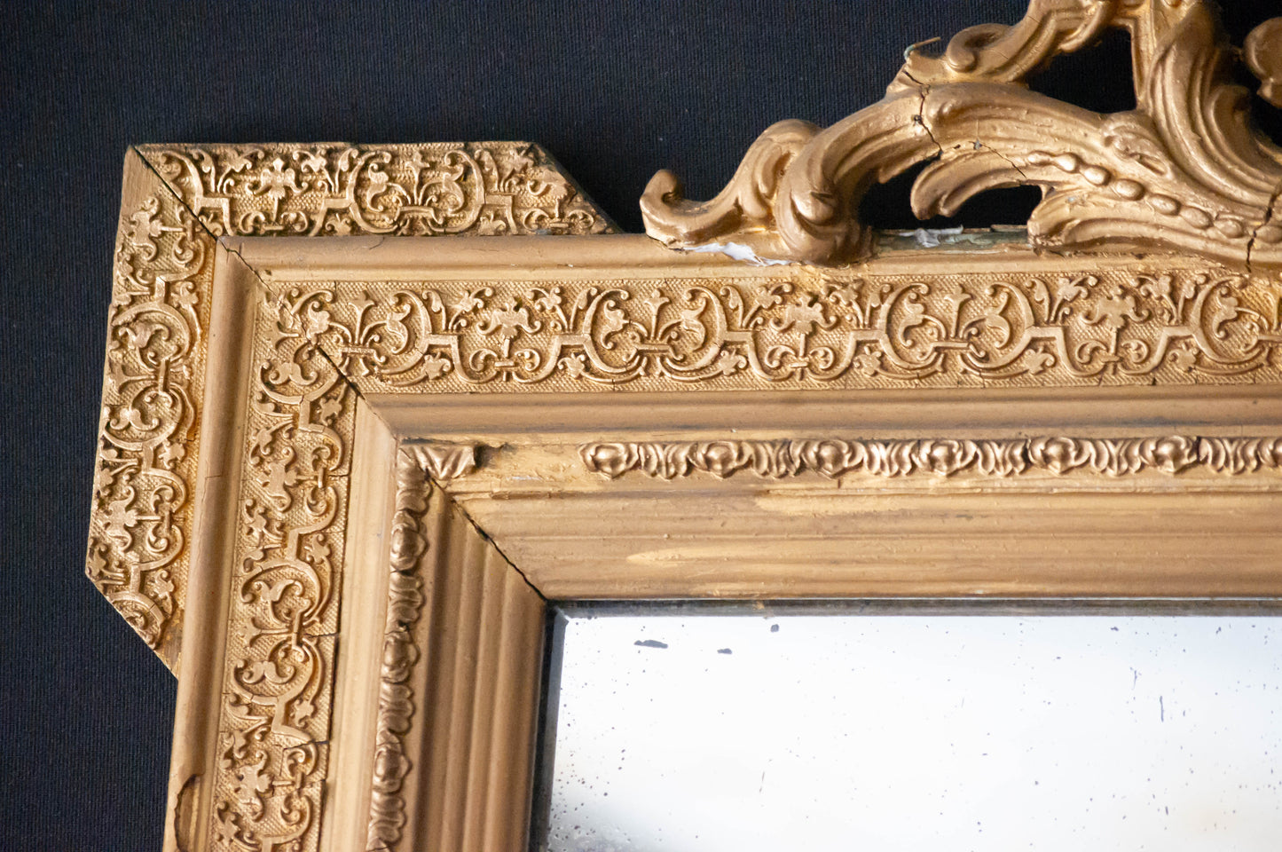 Miroir doré, en très bon état général, fronton en parfait état, cadre abimé à quelques endroits, visible sur les photos.