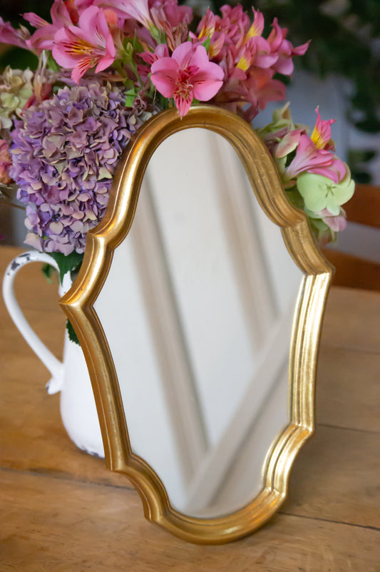 Petit miroir en bois, doré, avec accroche à l'arrière, parfait état.
